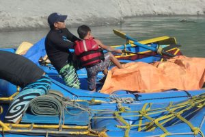 Nim Bahadur Magar teaching his son Kailash how to rig up a raft in Nepal