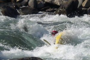 Kelly capsizing while learning to kayak on the Lower Seti River in Nepal during an early Paddle Nepal trip.